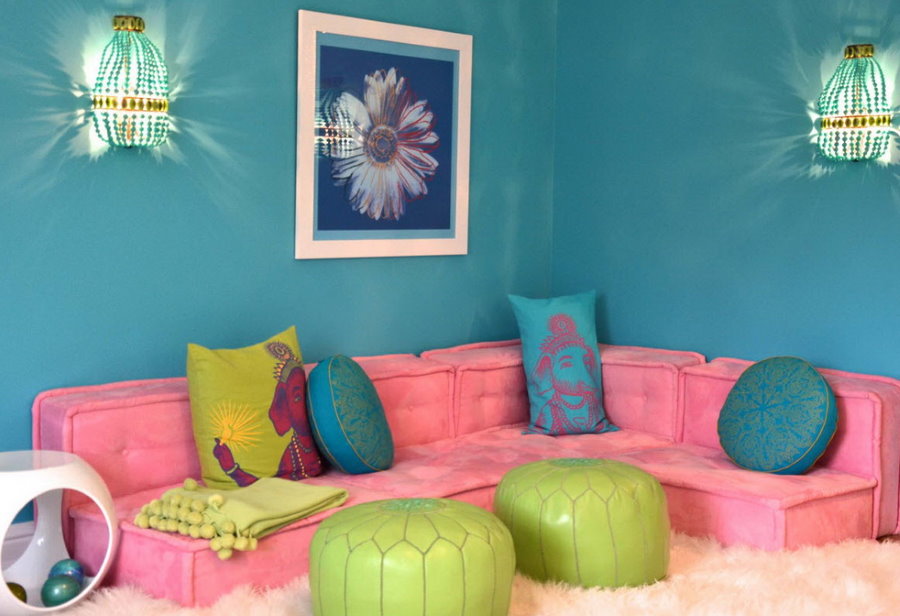 Розовый диванчик на фоне бирюзовой стены