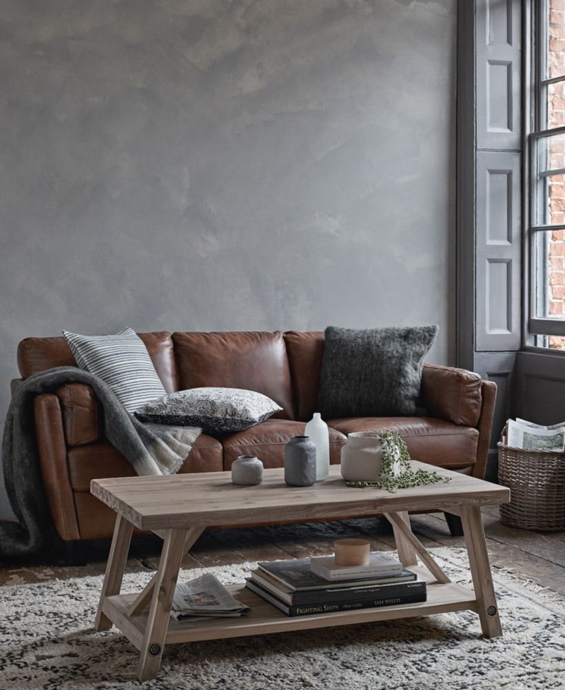 Коричневый диван у стены серого цвета