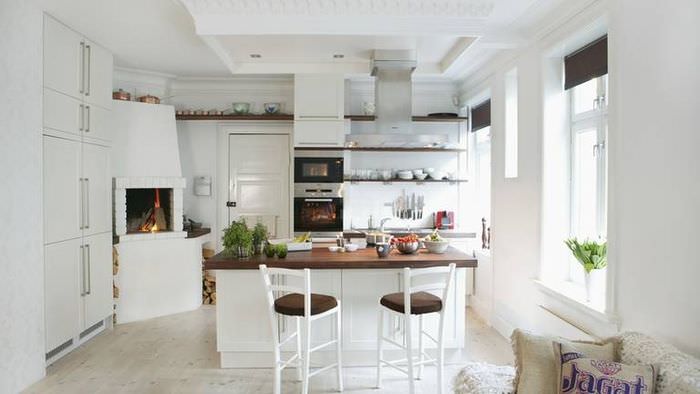 Интерьер белой кухни с камином